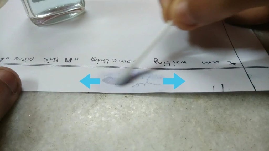 Chấm nhẹ đầu tăm bông có tẩm cồn lên vết mực in cần tẩy