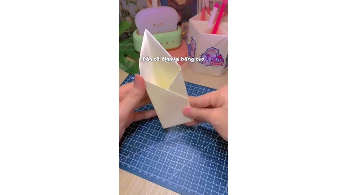Dùng băng keo dán cố định hình hộp lại, ta được một khay đựng bút