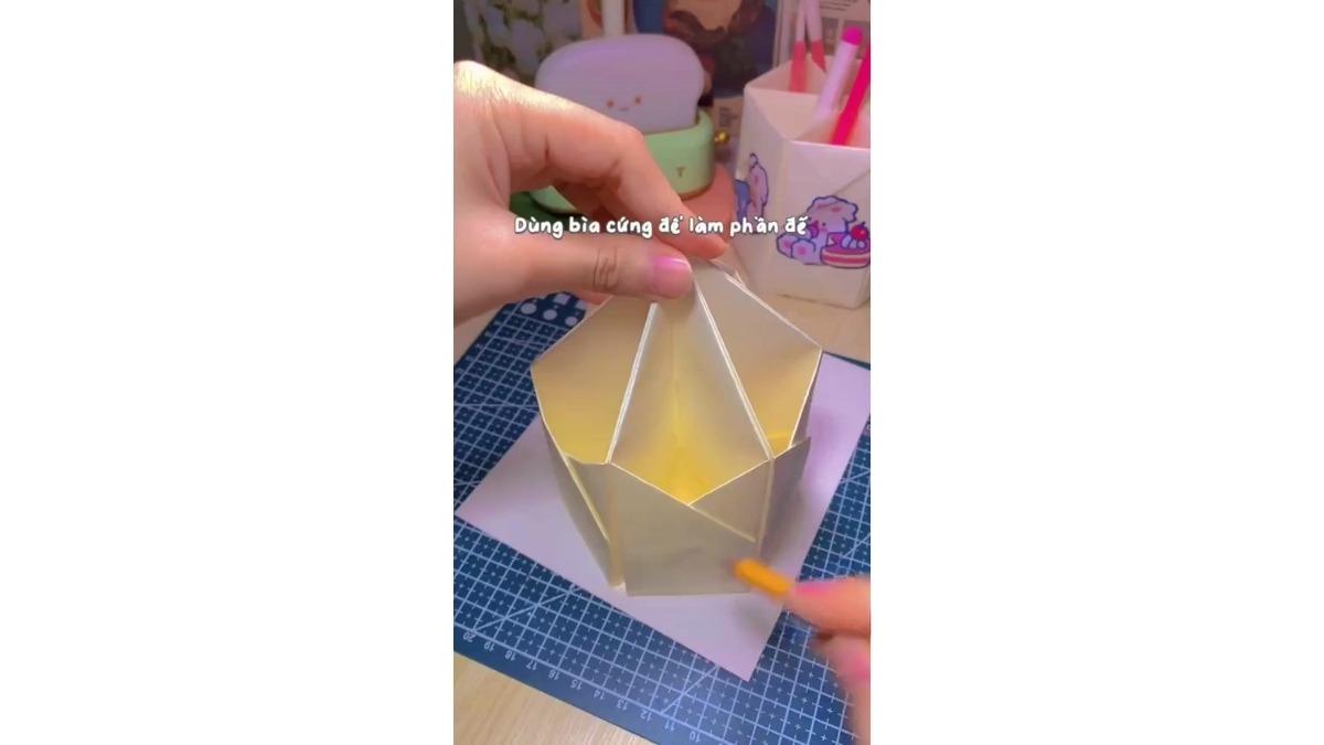 Đặt hộp bút lên một tờ bìa cứng. Dùng bút chì vẽ theo hình đa giác dưới đáy hộp