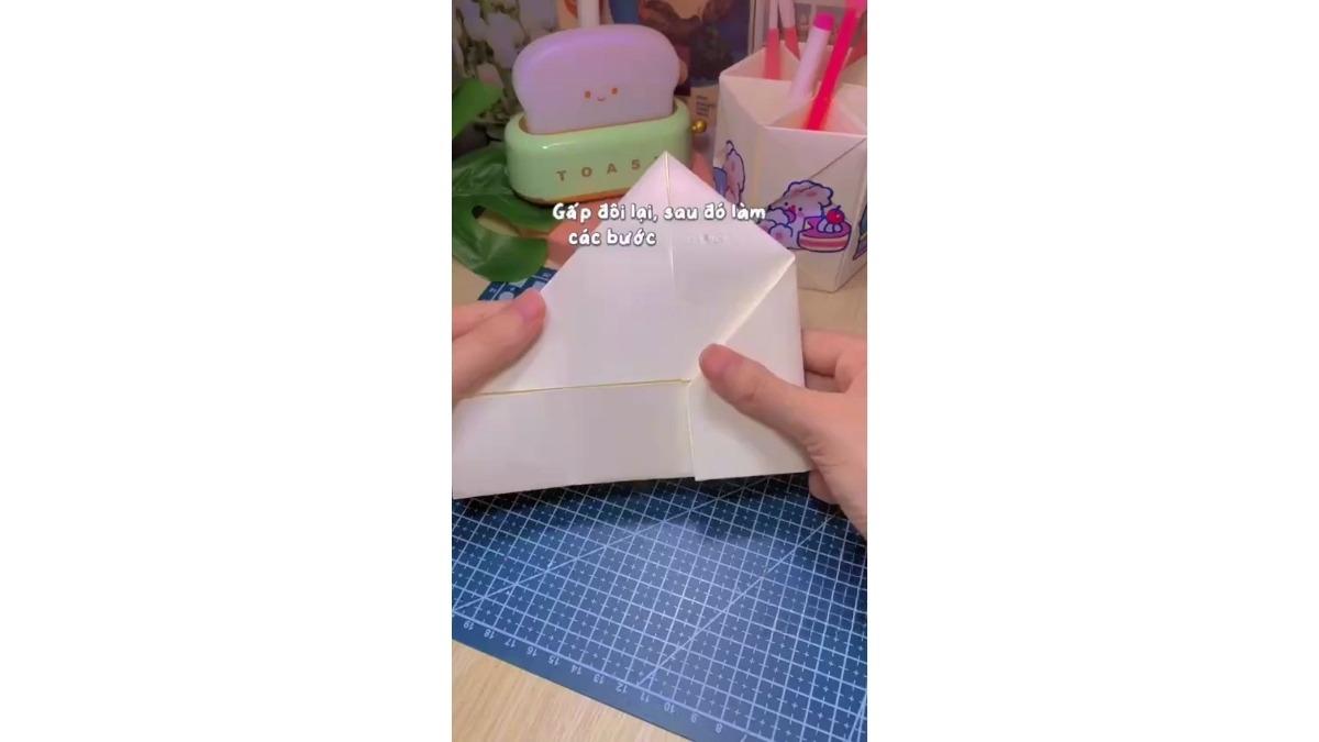 Gấp nửa dưới sao cho mép chạm nếp tạo được ở bước trên